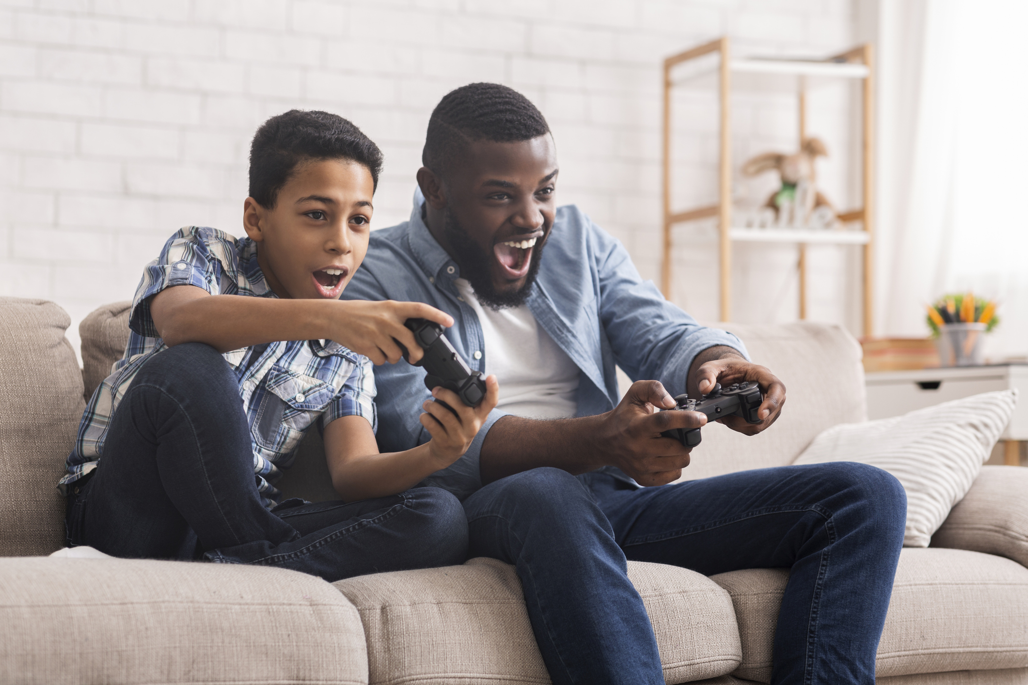 Cheerful Black Father And Son Competing In Video Games At Home