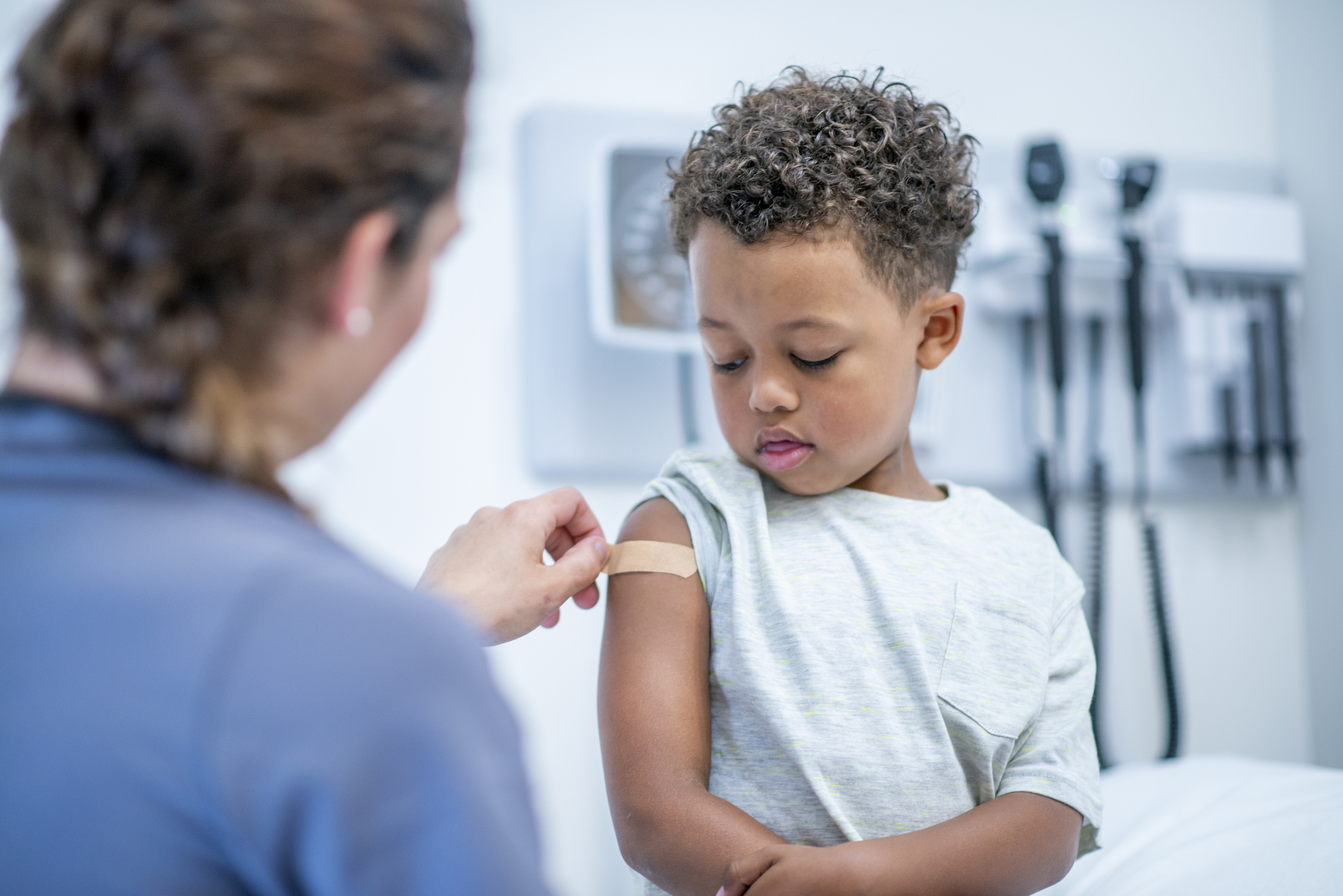 Doctor Putting Bandage on Little Boy stock photo