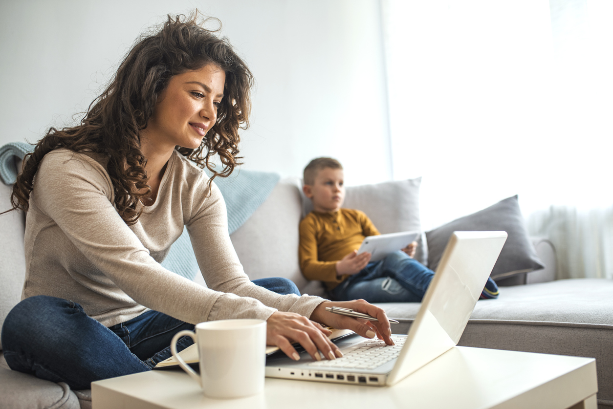 Busy young woman with son at home.