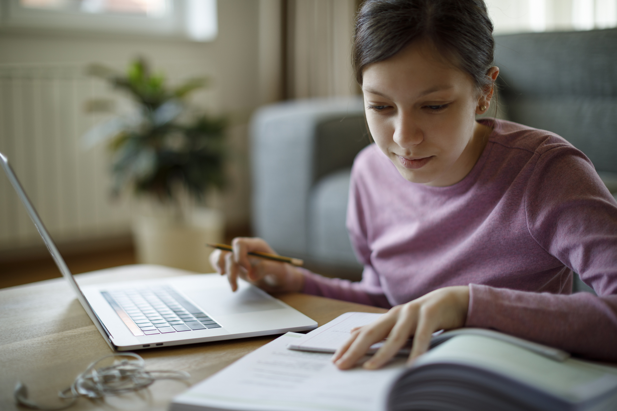 Teenage girl using laptop for studying at home