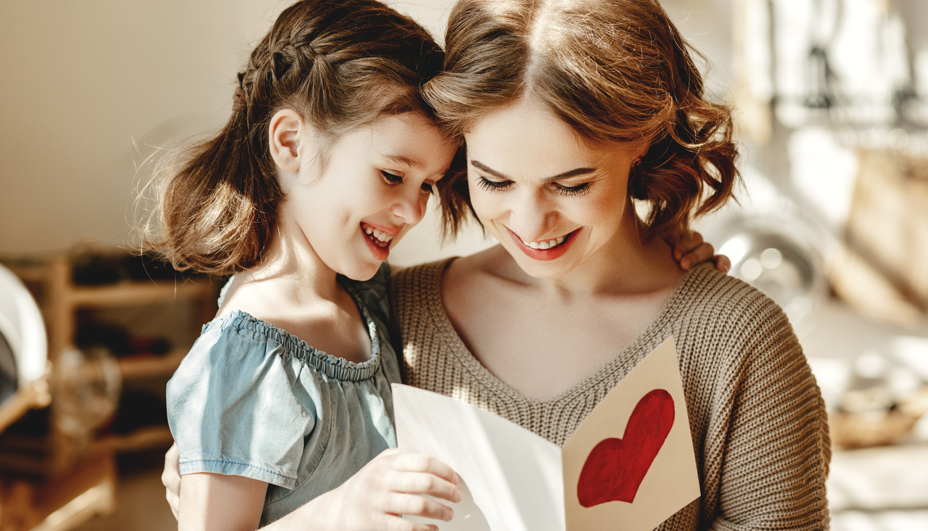 Little girl giving card to mom