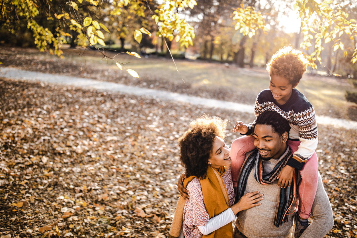 Happy black family spending an autumn day at the park.