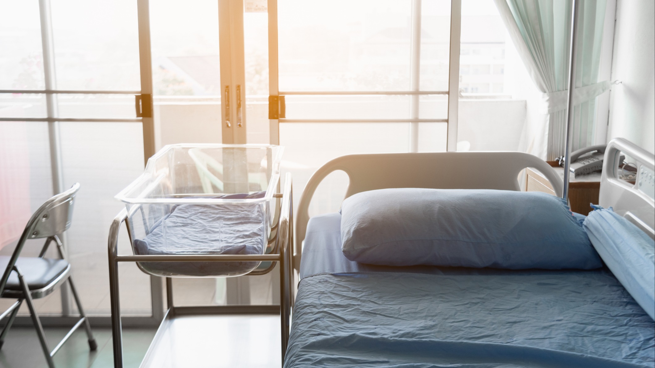 Empty hospital bed and baby bassinet