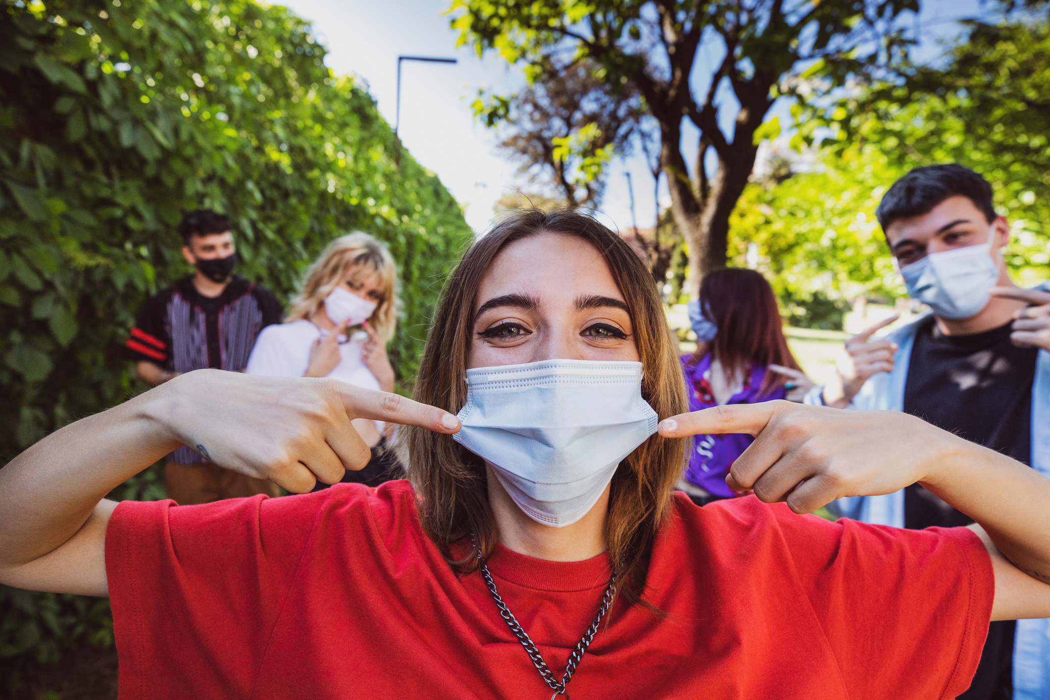 Group of teenagers posing showing their protective face masks