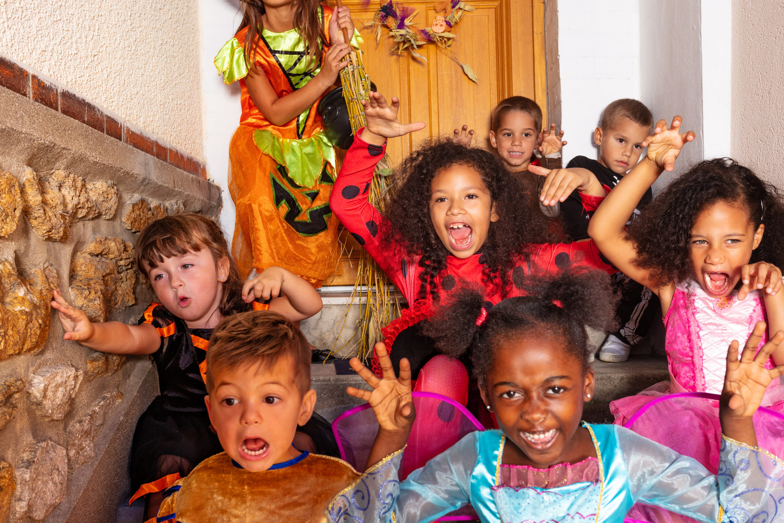 Group of kids in Halloween costume on home stairs