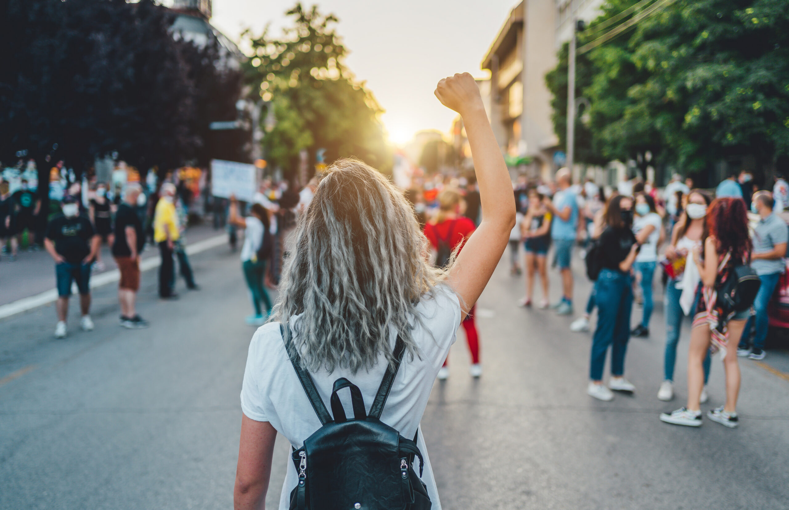 Young woman protester raising her fist up