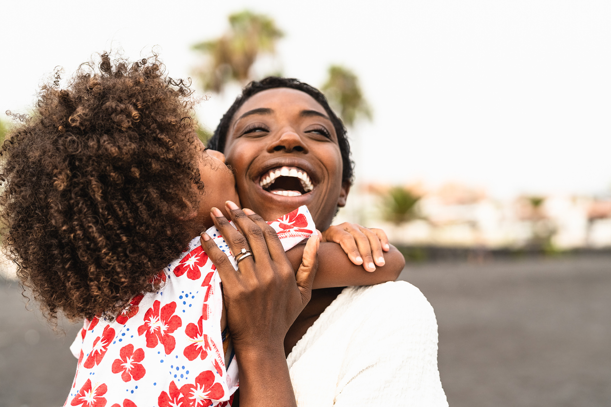 Happy African family on the beach during summer holidays - Afro American people having fun on vacation time - Parents love unity and travel lifestyle concept