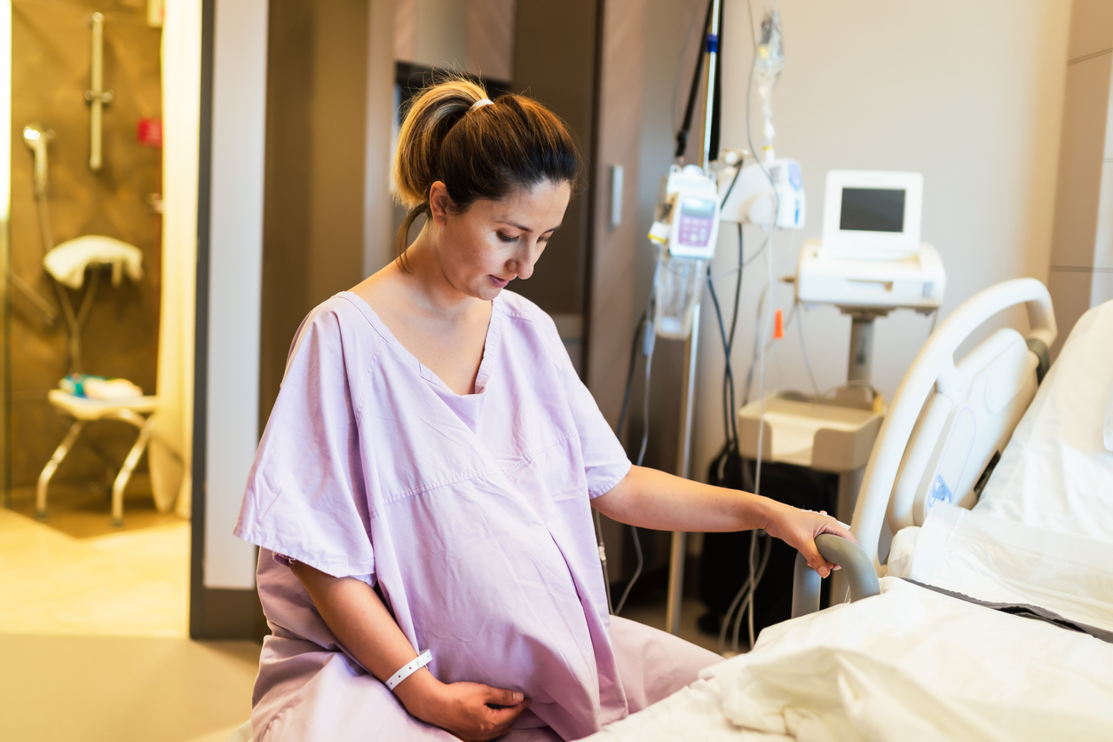 Young pregnant woman in the hospital ward sitting on fitness ball and ready to delivery a baby.