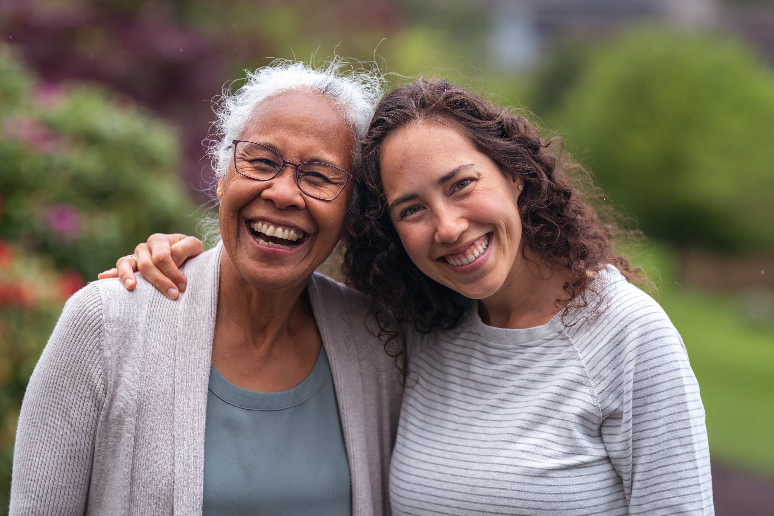 Mixed race mother and daughter walk and talk together outside