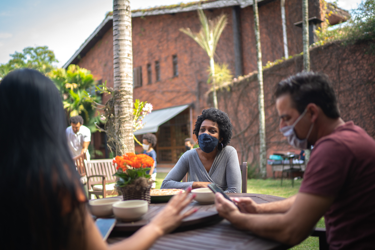 Friends reunited in the backyard, talking and using smartphone