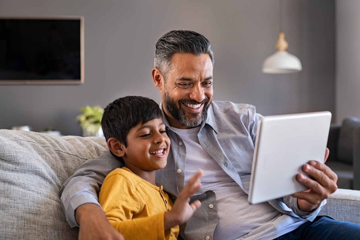 Father and son using digital tablet to make a video call