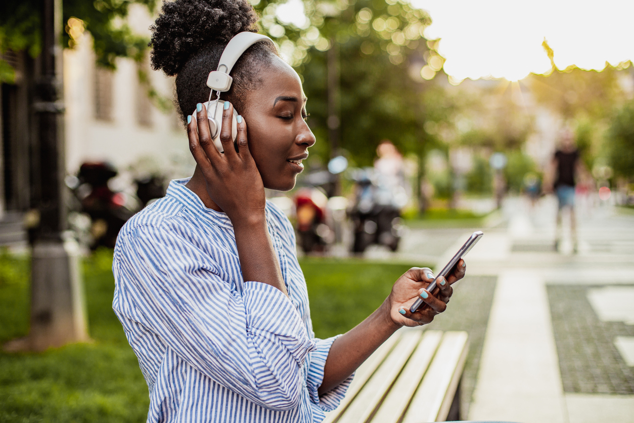 Modern African American woman with smart phone and headphones