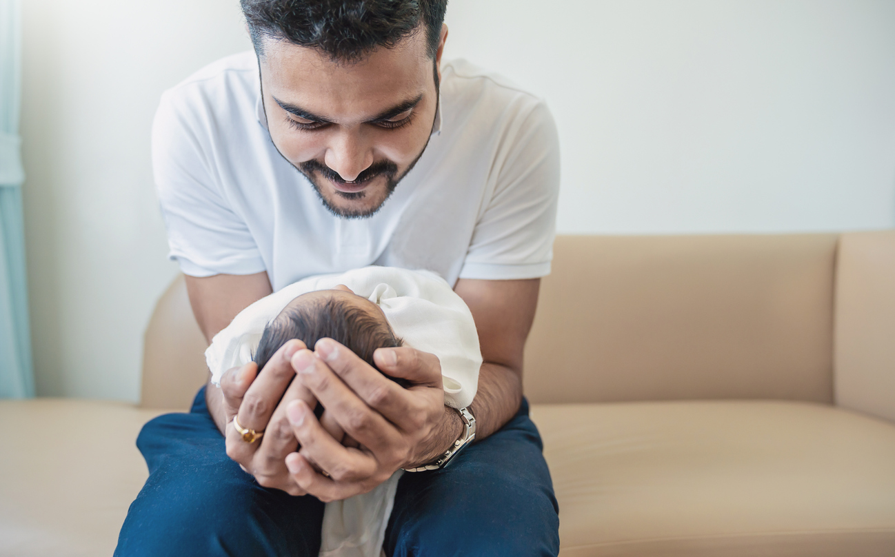 Closeup portrait of young asian Indian father holding his newborn baby with copy space. Healthcare and medical daycare nursery love lifestyle together single dad fatherâs day holiday concept