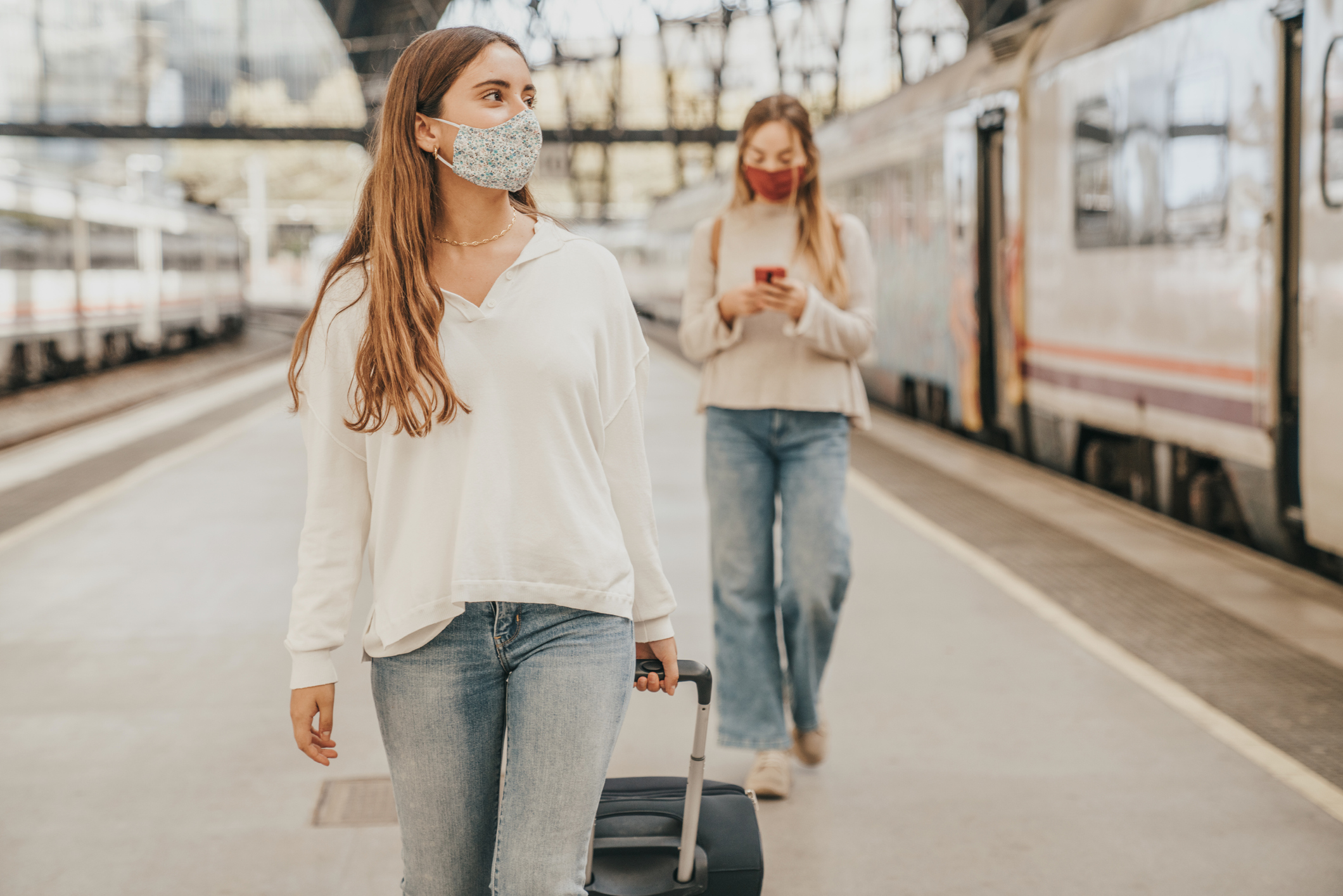 Friends looking at the phone at train station