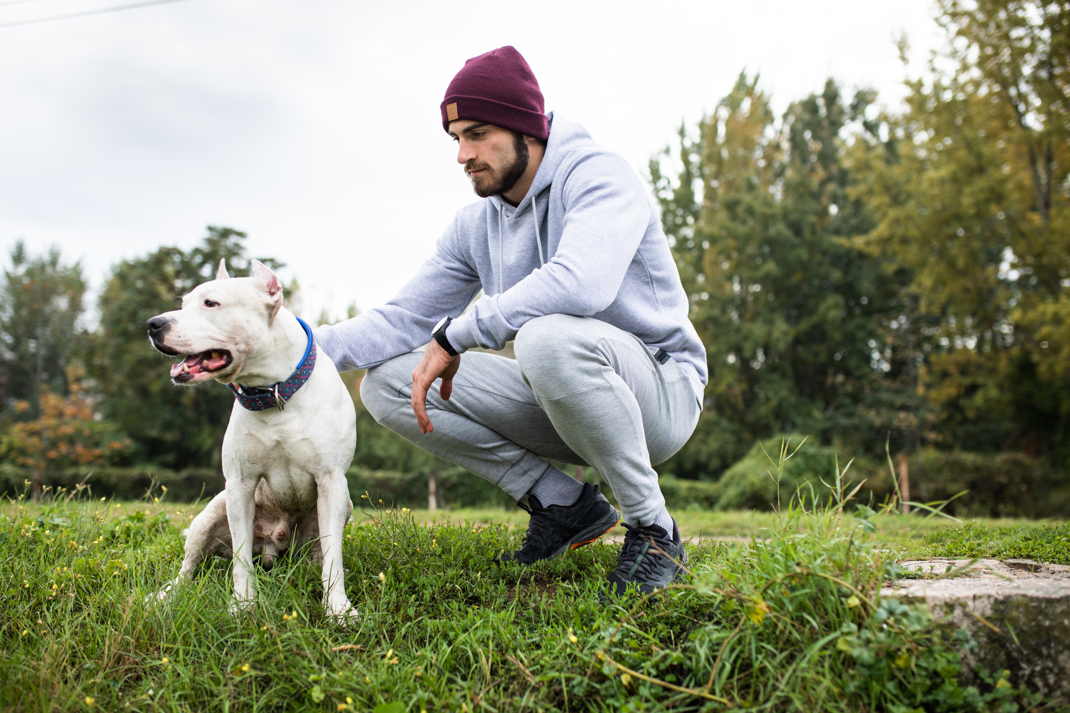 A handsome young man petting his dog