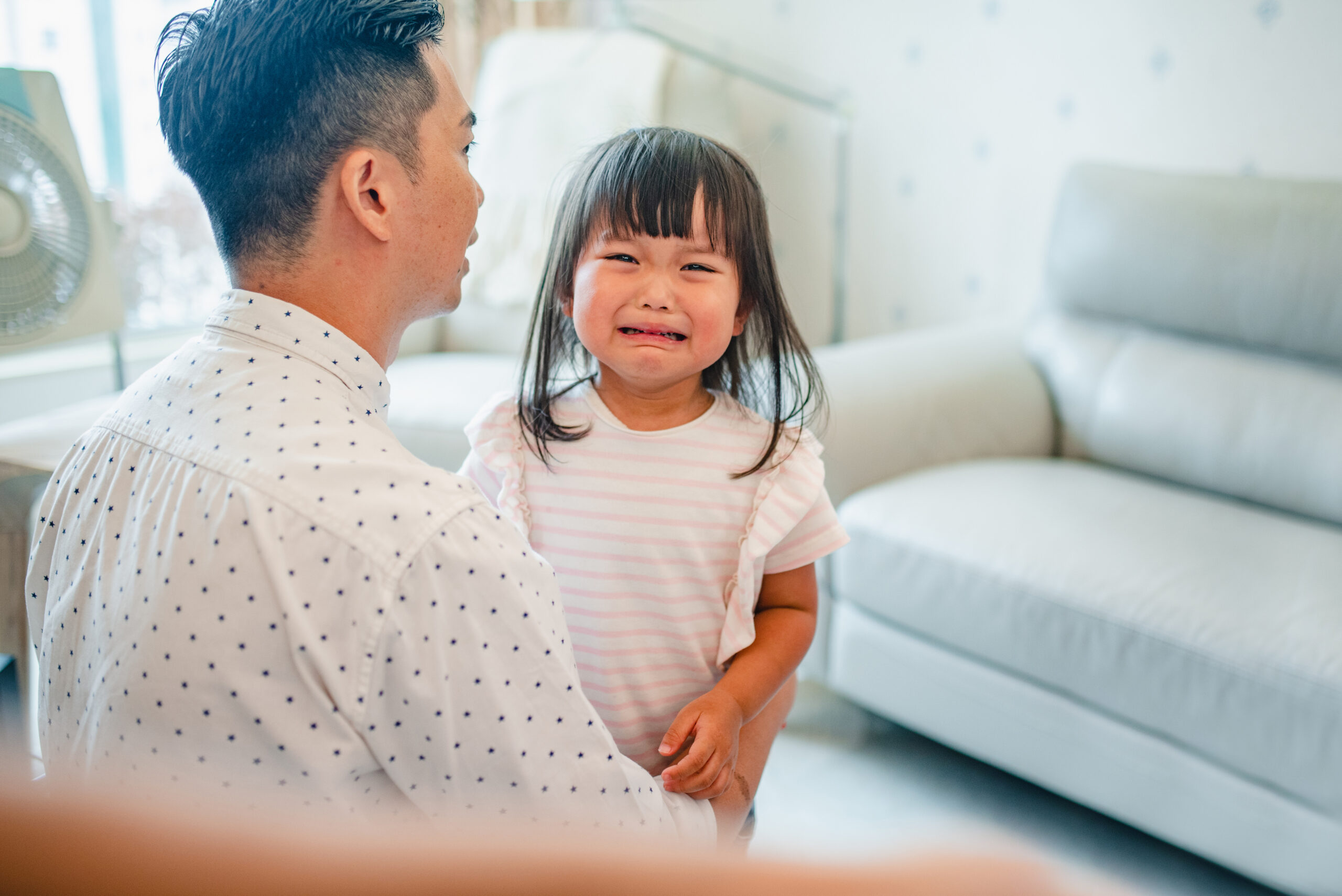 Chinese Father and Crying 3 Year Old Daughter at Home