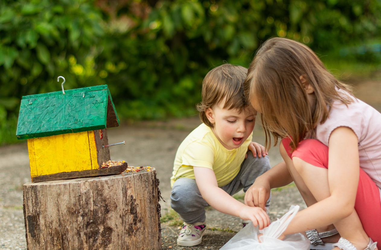 Children feeding birds outdoors