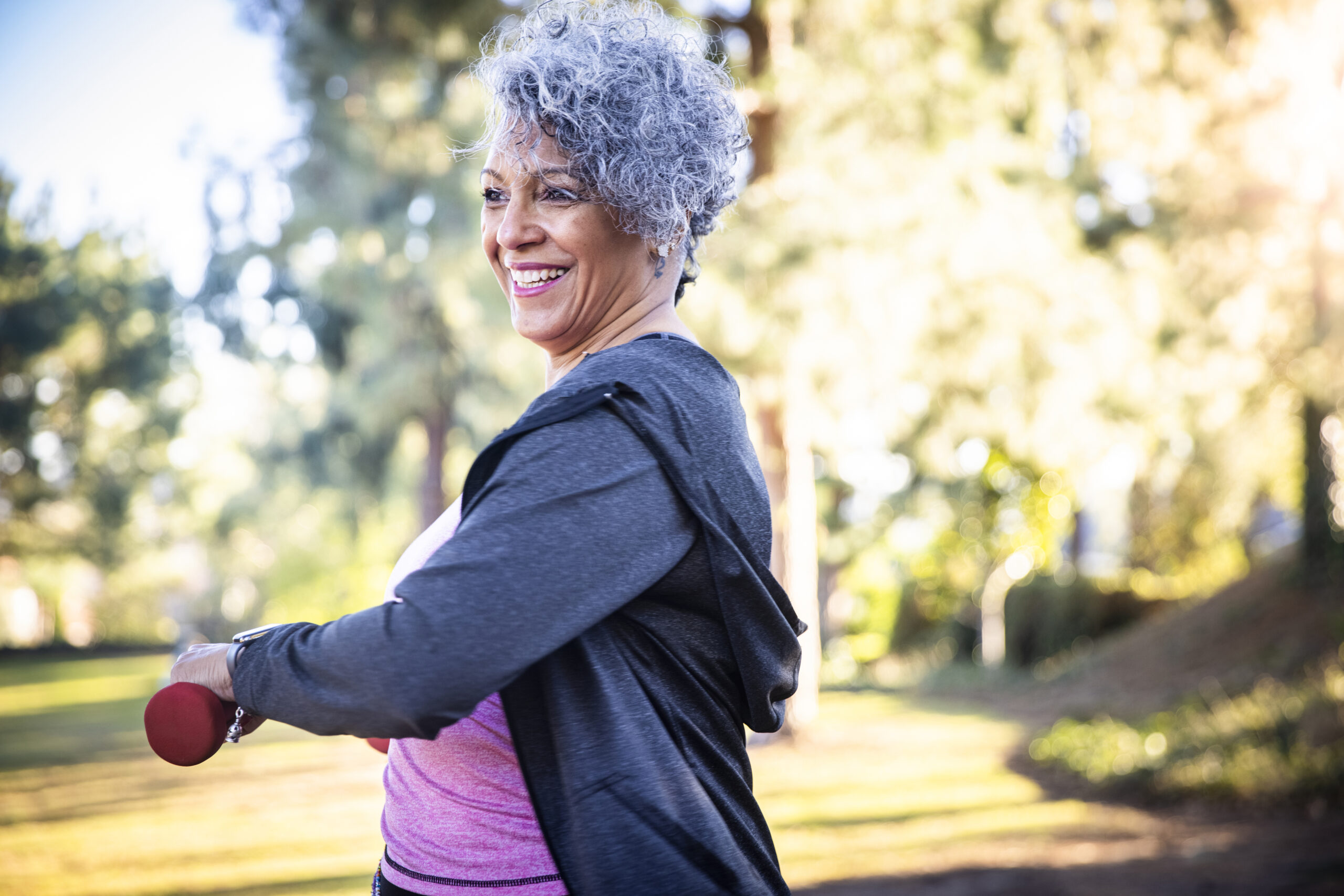 Senior Black Woman Stretching and Exercising with Weights