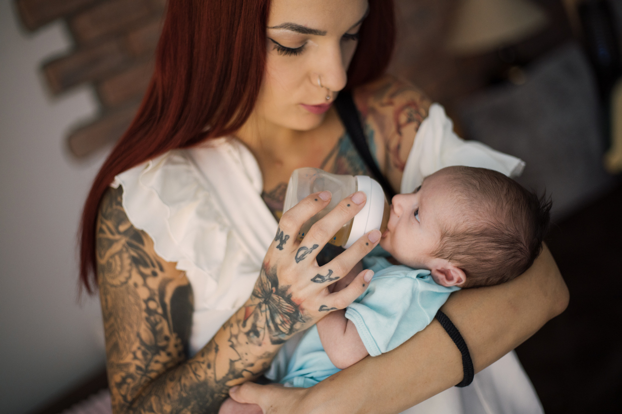 mother feeding her new born adorable baby boy