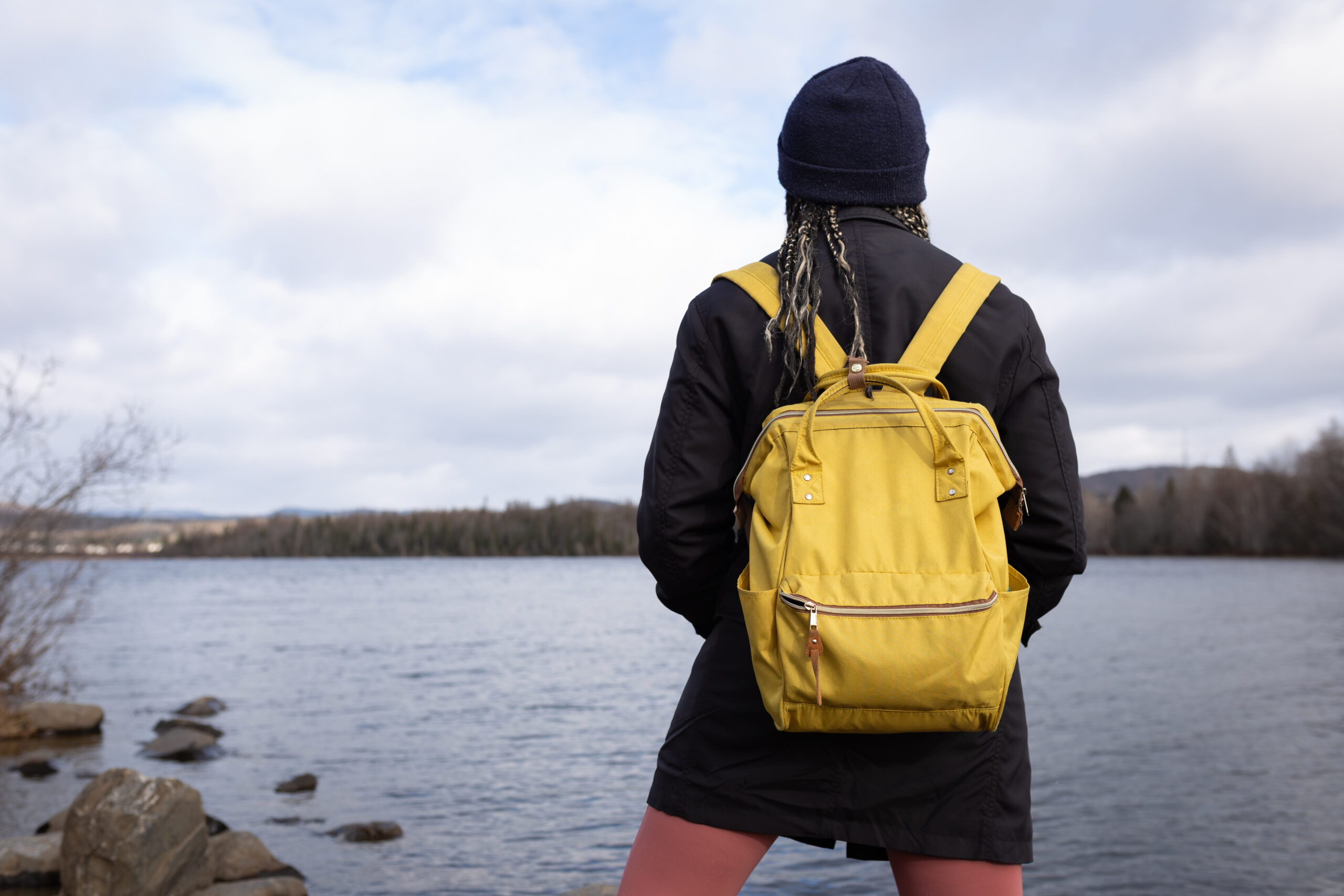 Young woman standing alone behind Lake