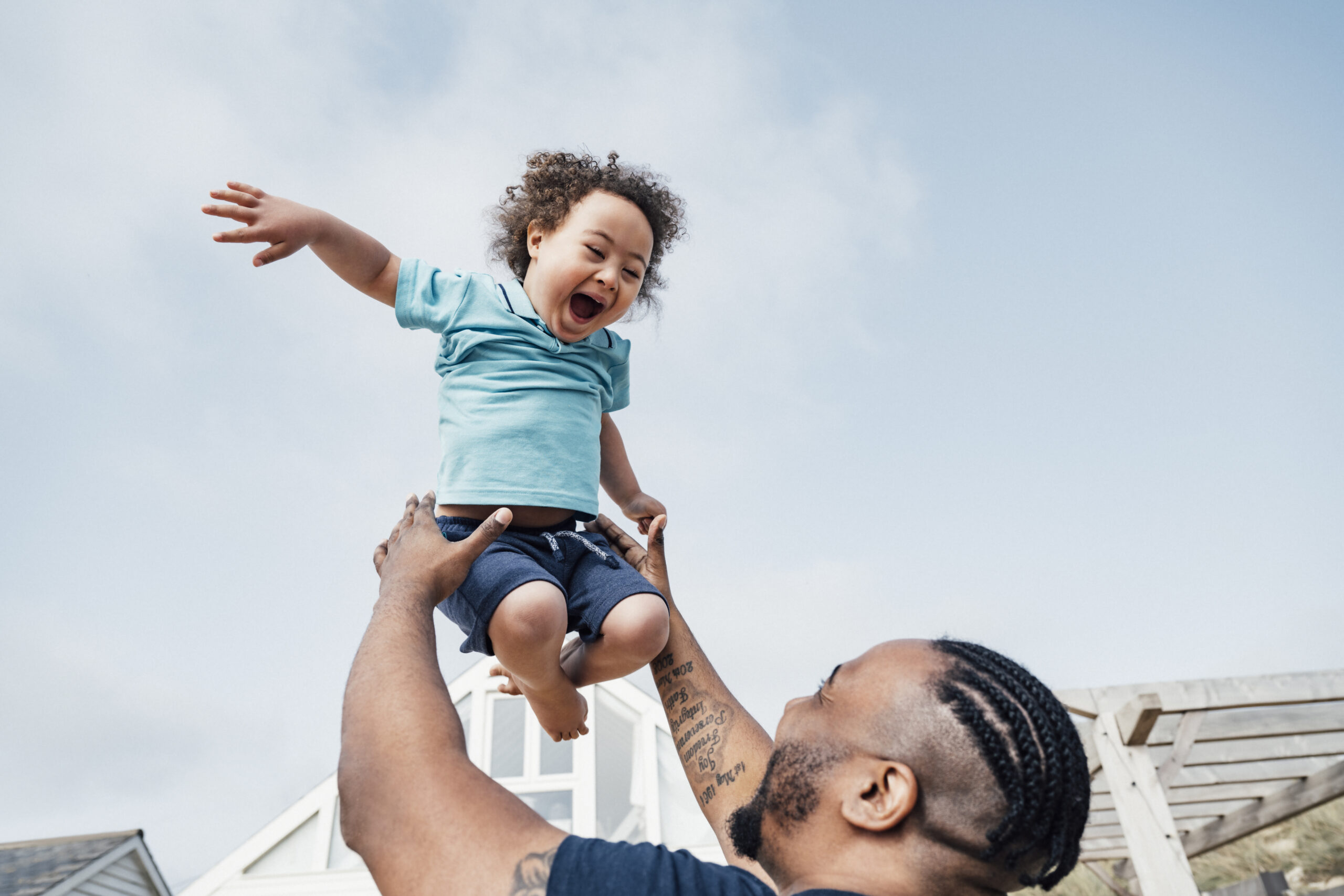 Young boy with Down Syndrome expressing joy in mid-air