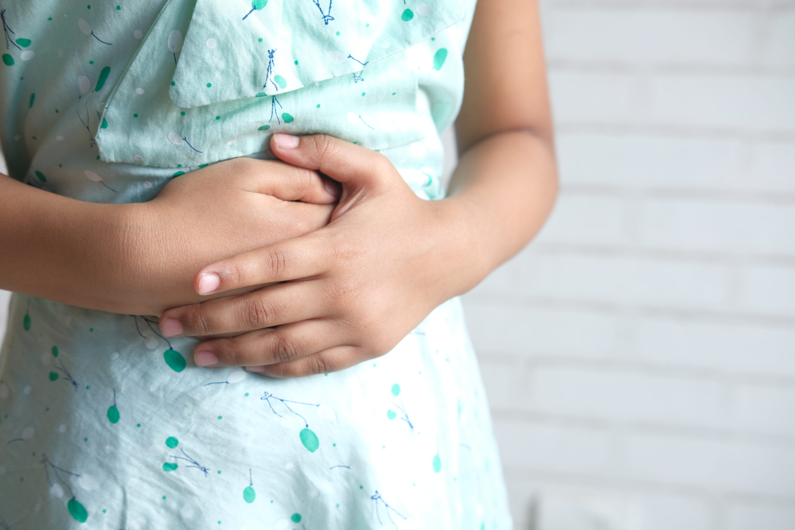 child girl suffering stomach pain close up.