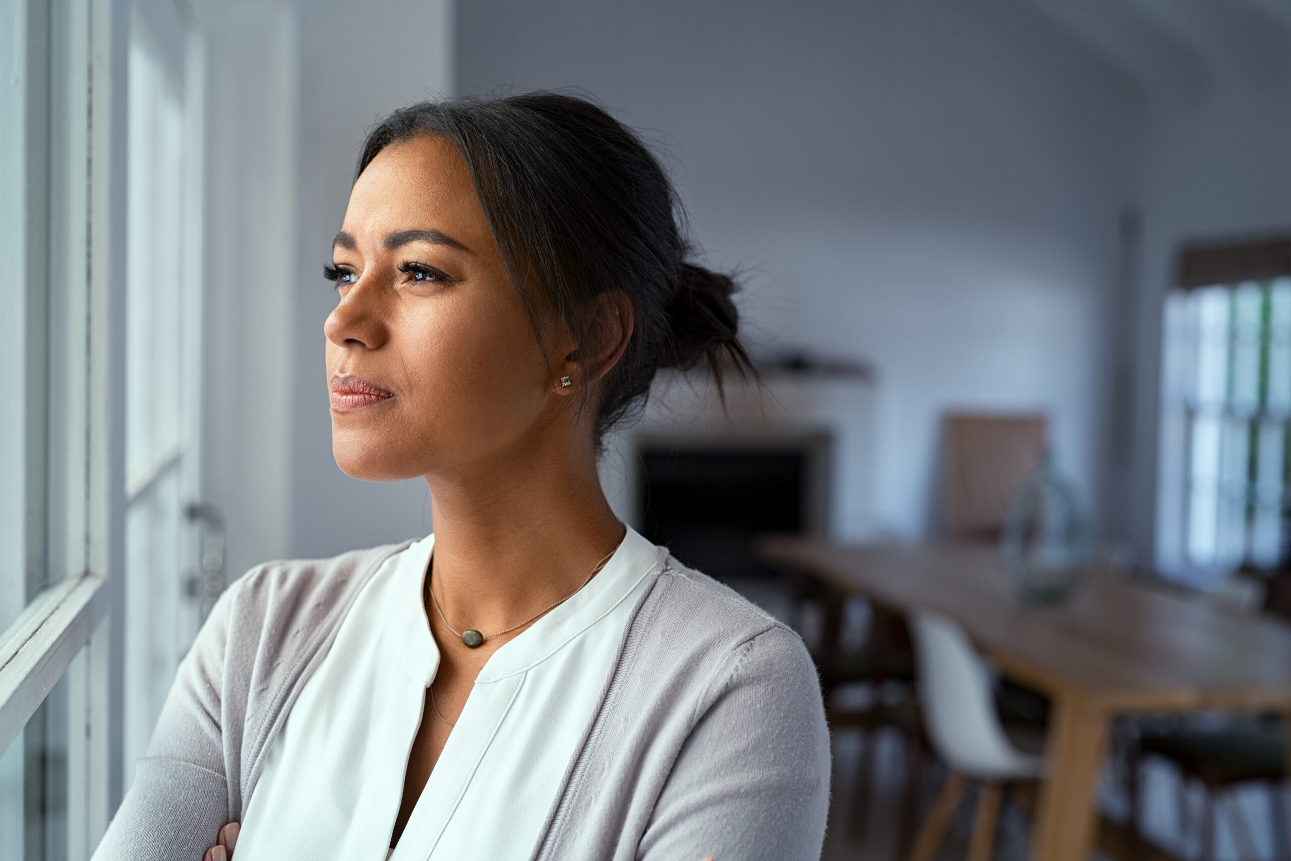 Thoughtful black woman looking outside window