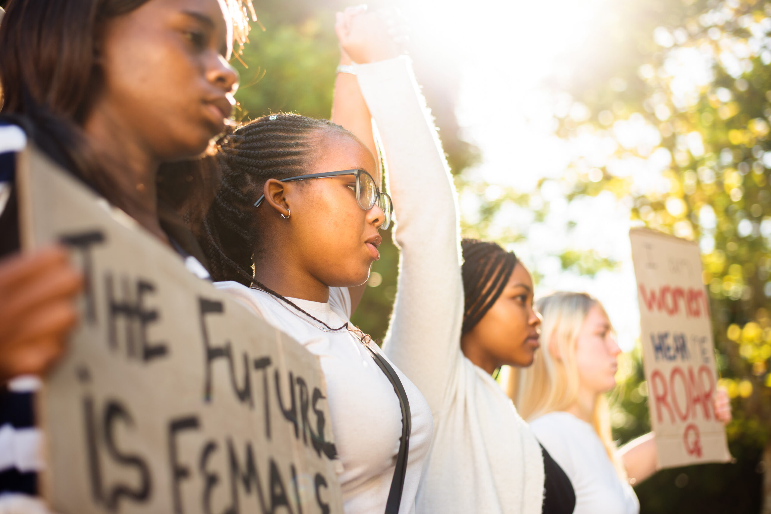 Diverse teenage girls holding hands during a women's rights march