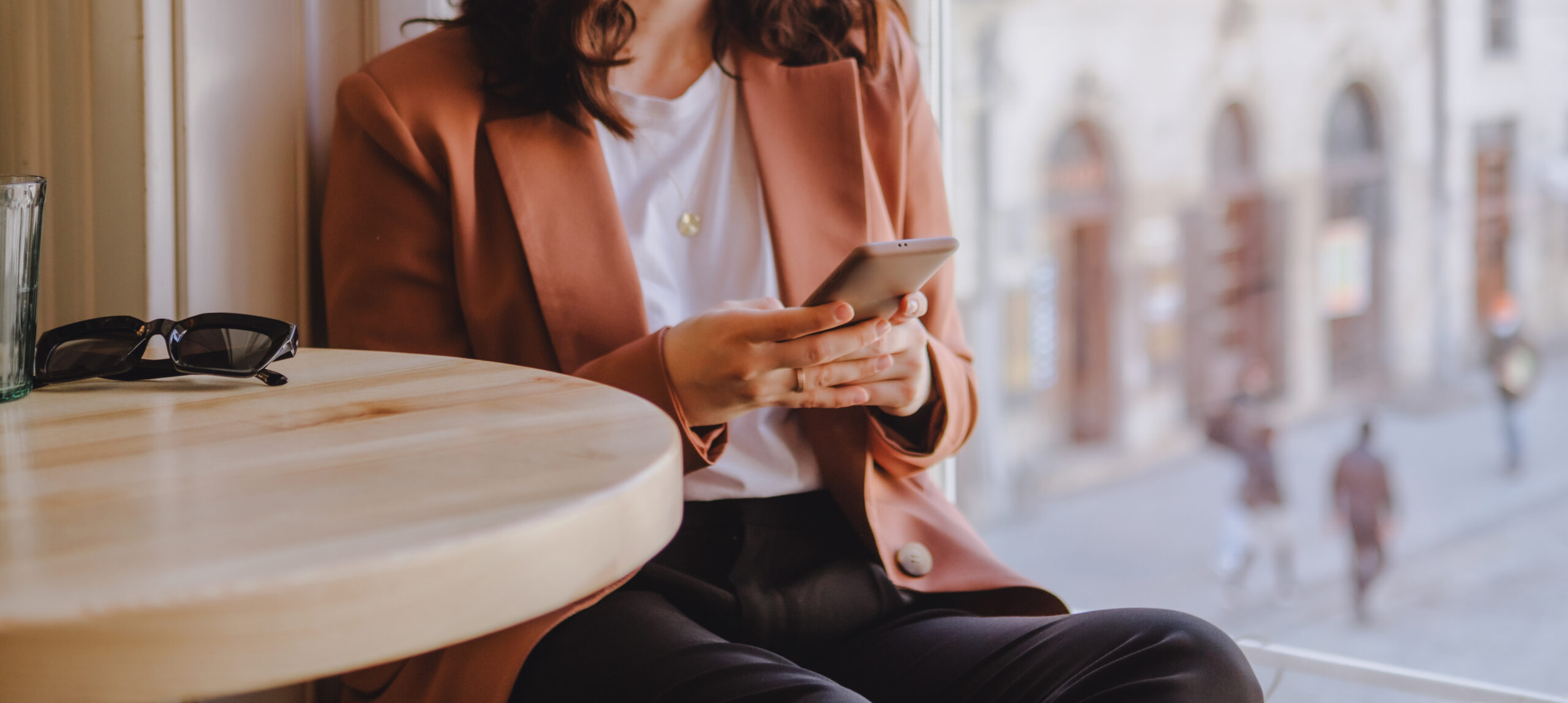 woman sitting in cafe texting on the phone