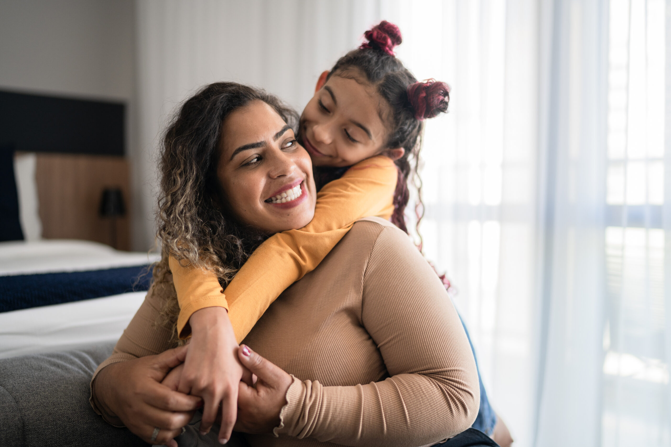 Happy mother and daughter sharing bonding moment at home