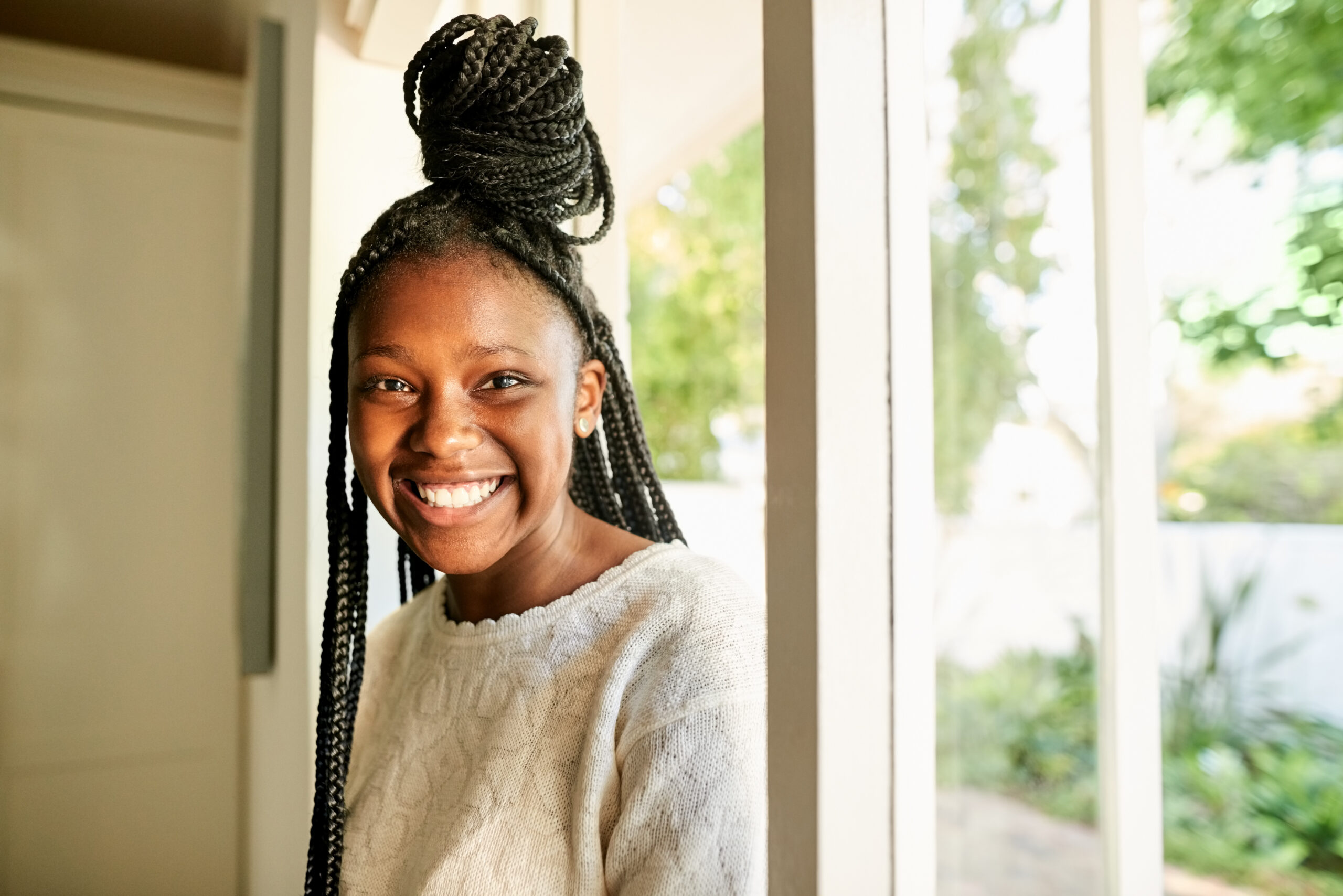 Cheerful african teenage girl coming in her house