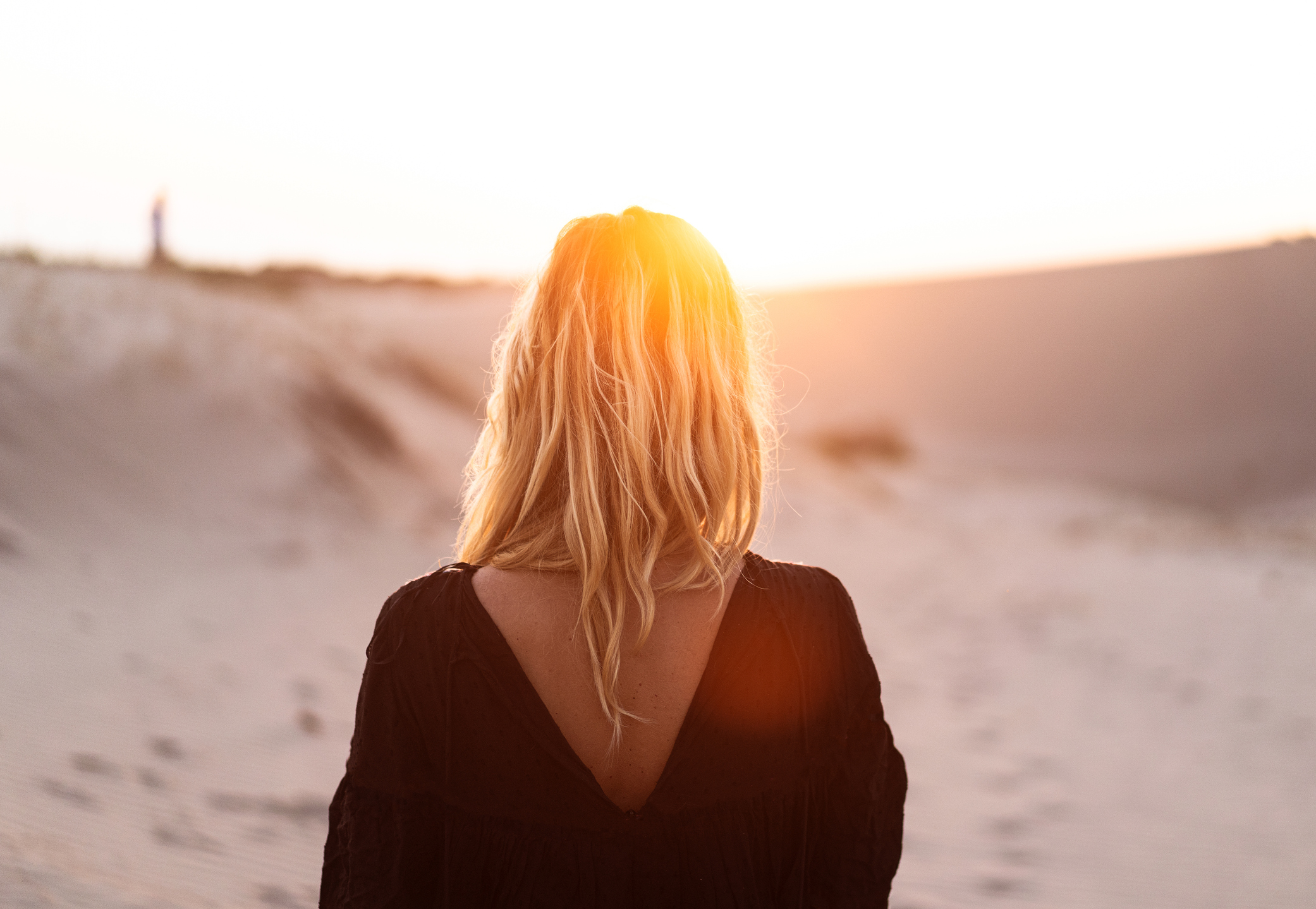 rear view of blonde beautiful woman at sunset or sunrise