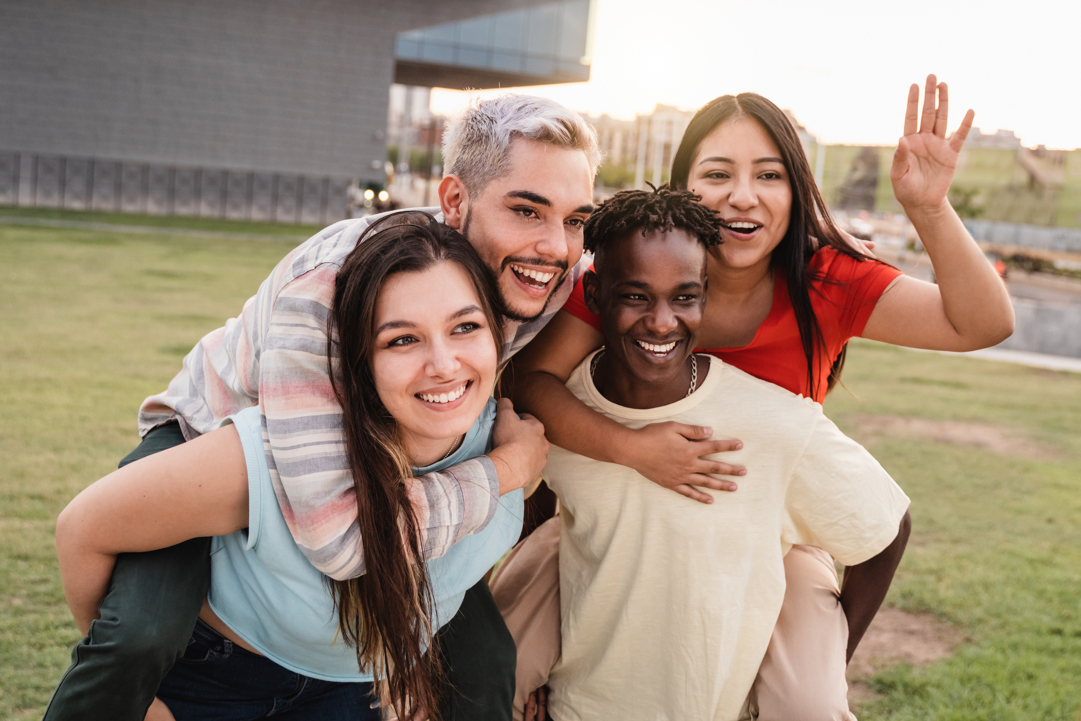 Young diverse people having fun together outdoor at city park - Focus on left girl face