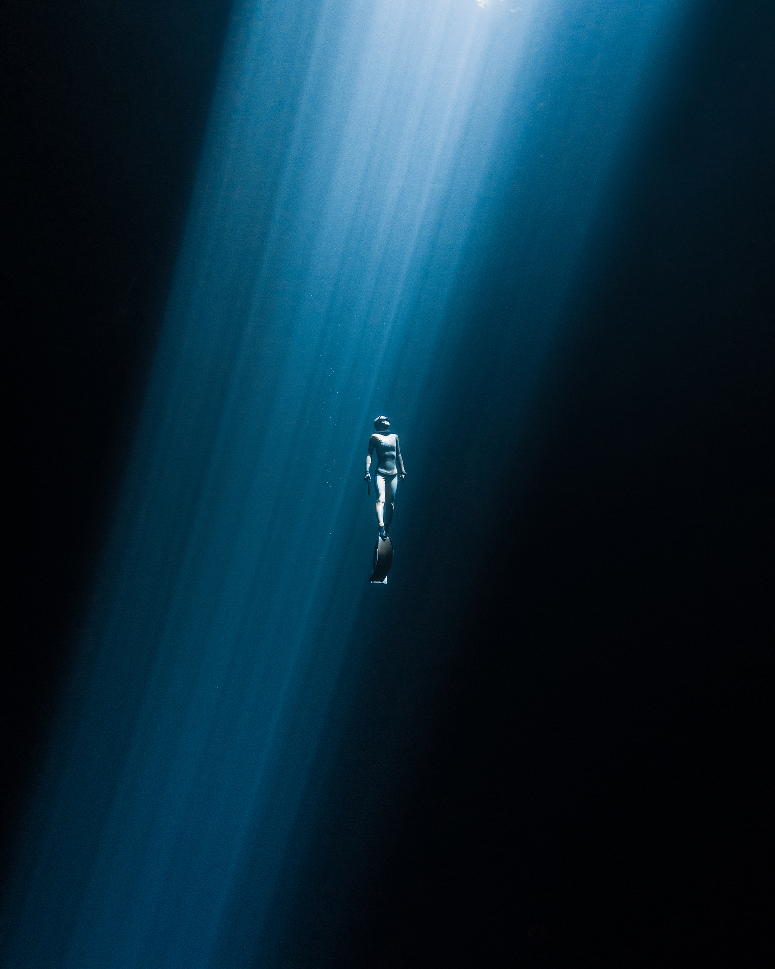 Japanese freediver swimming to the surface in a  Mexican Cenote