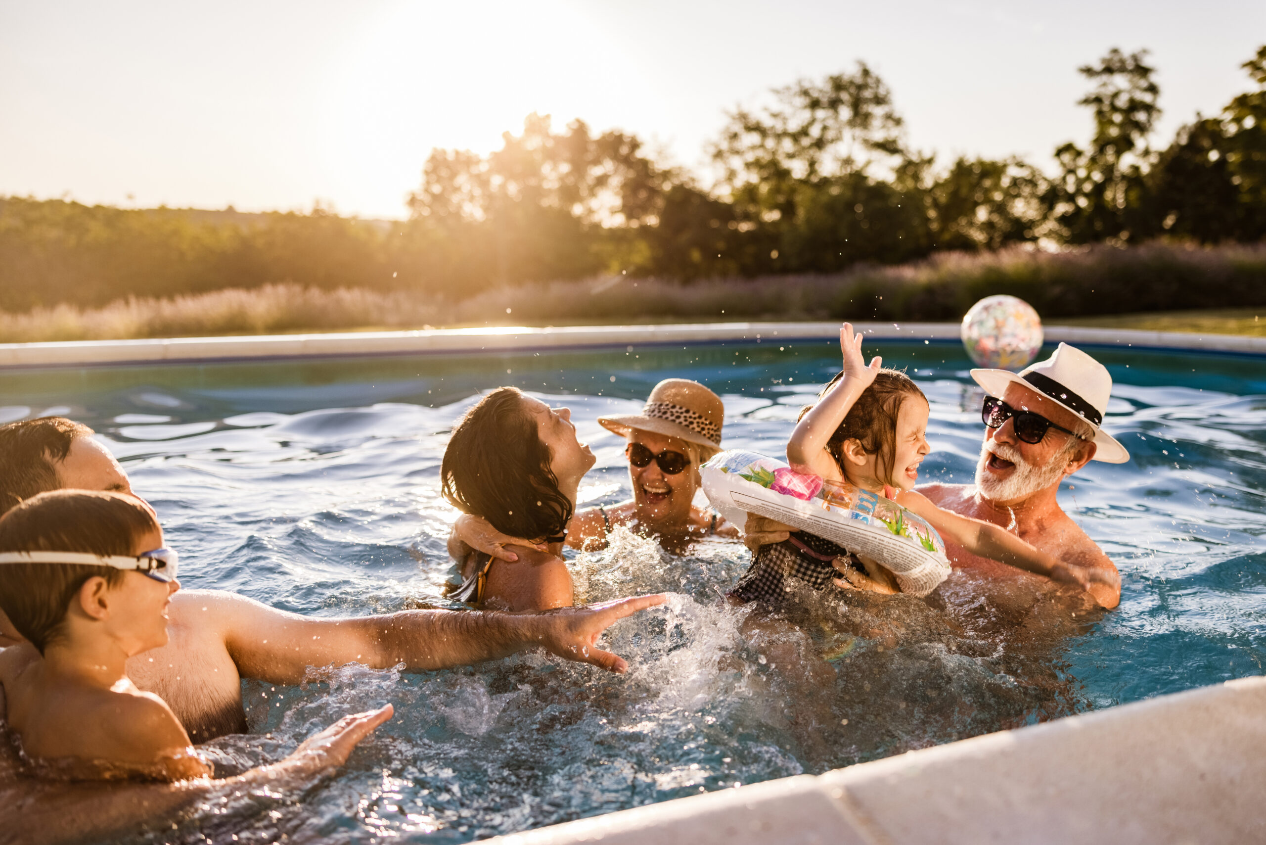 Playful extended family having fun in the swimming pool.