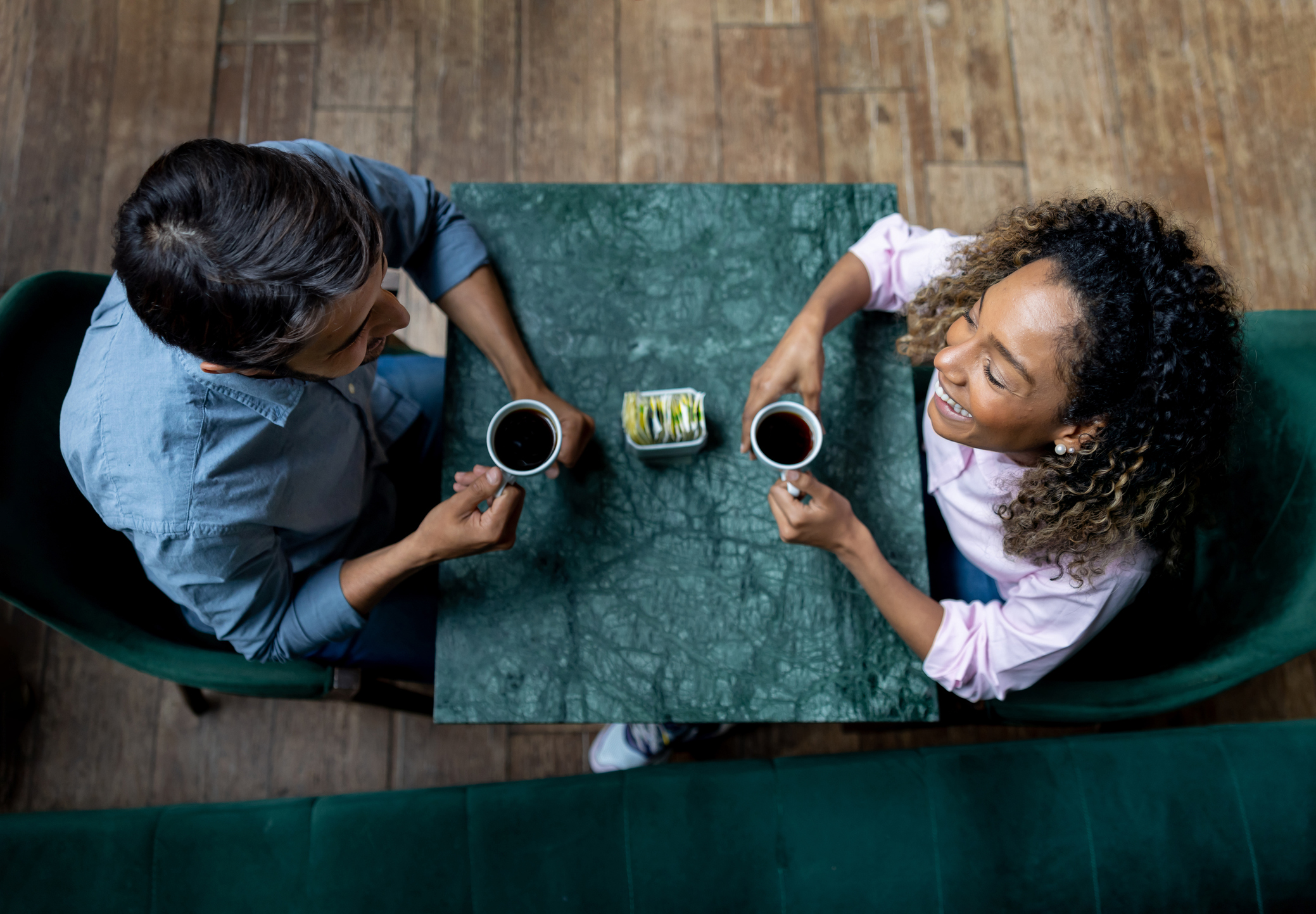 Happy couple smiling while having a cup of coffee at a cafe