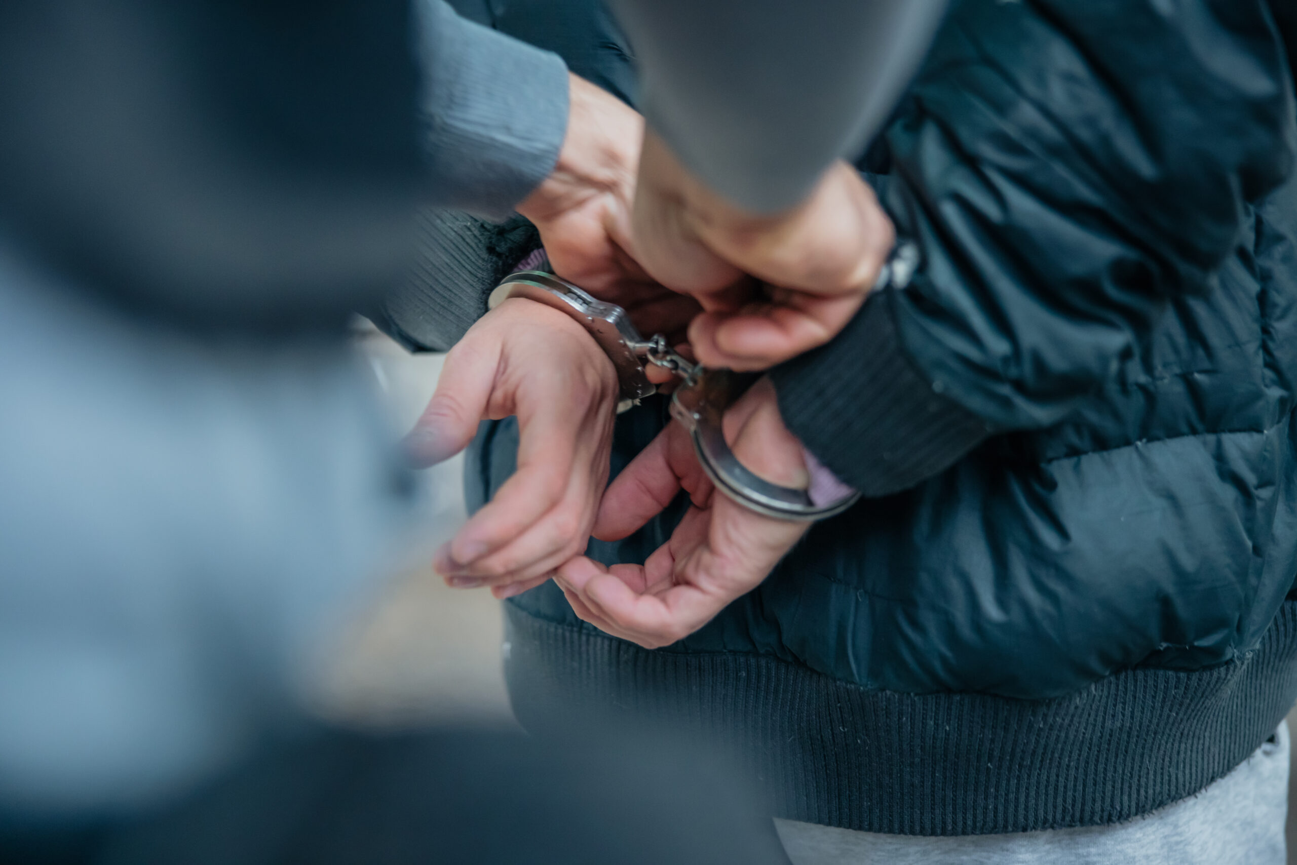 Policeman unlocking a handcuffs on the criminal's back