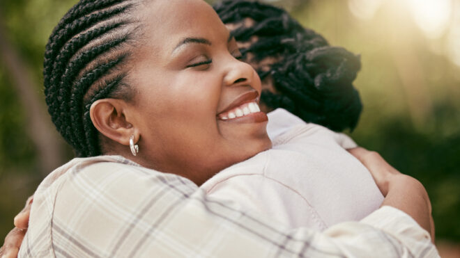 Mother and Daughter Hugging and Smiling