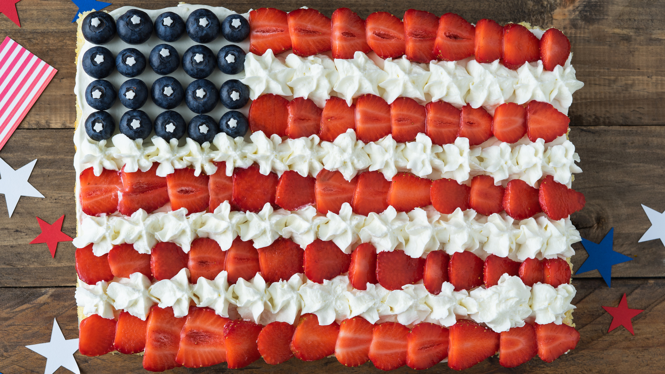 Cake with the colors of the US flag on a wooden background. Copy space. Independence Day Celebration.