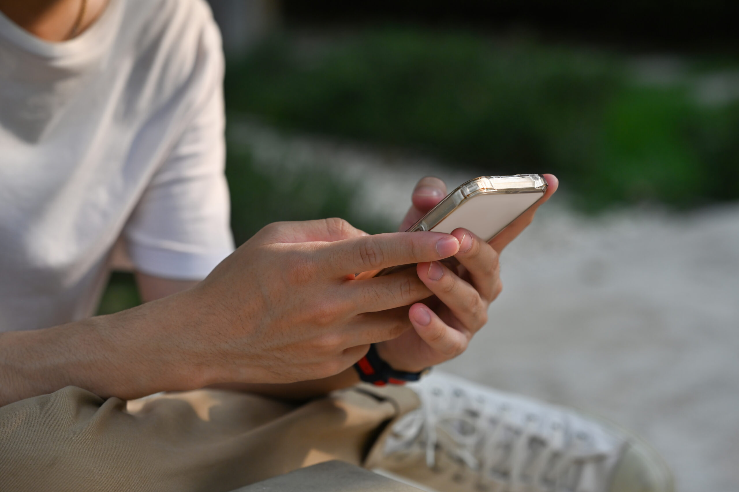 A close up of a male enjoying using a smartphone in an outdoor place. Business and technology concepts.