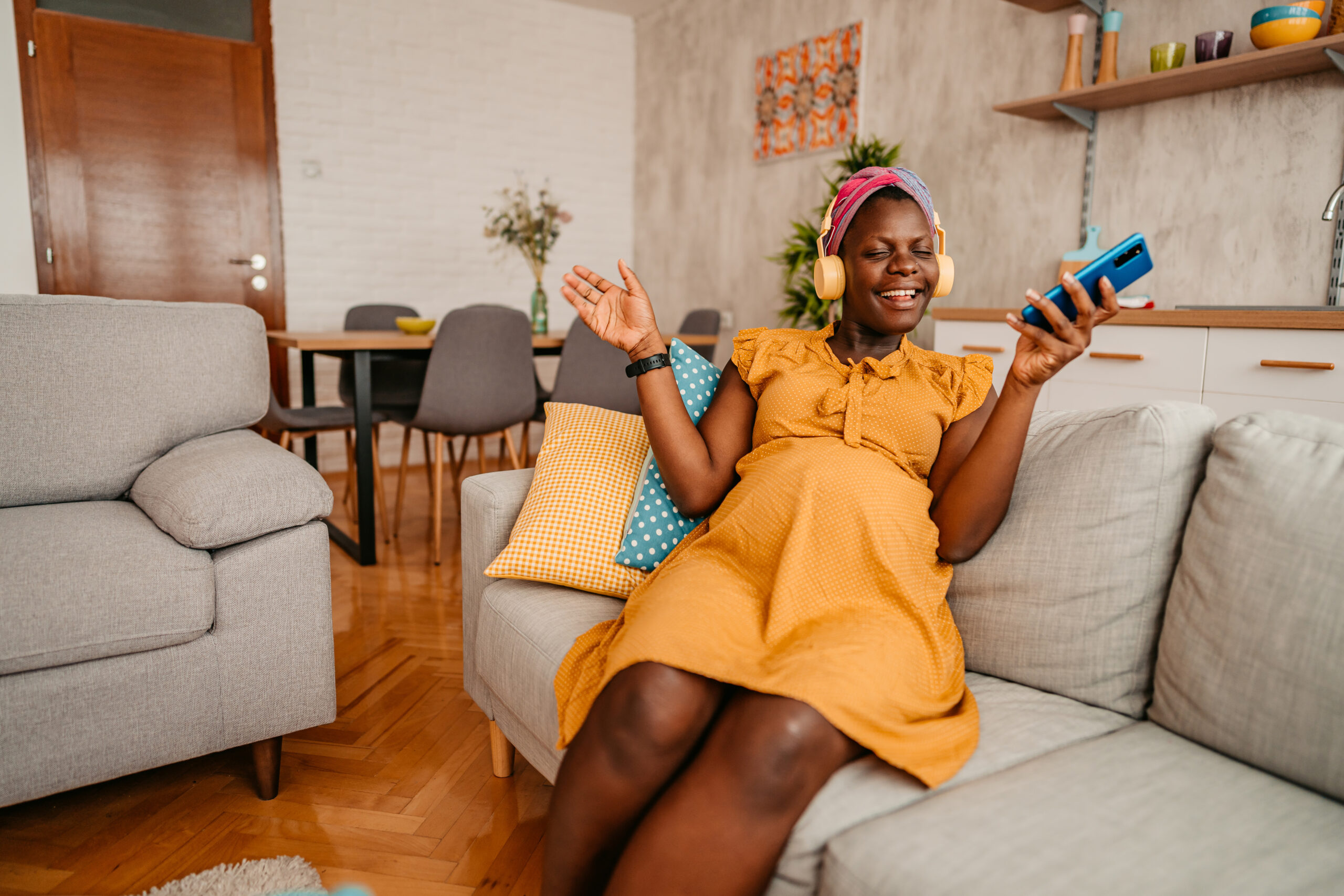 Pregnant Woman Listening To Music At Home