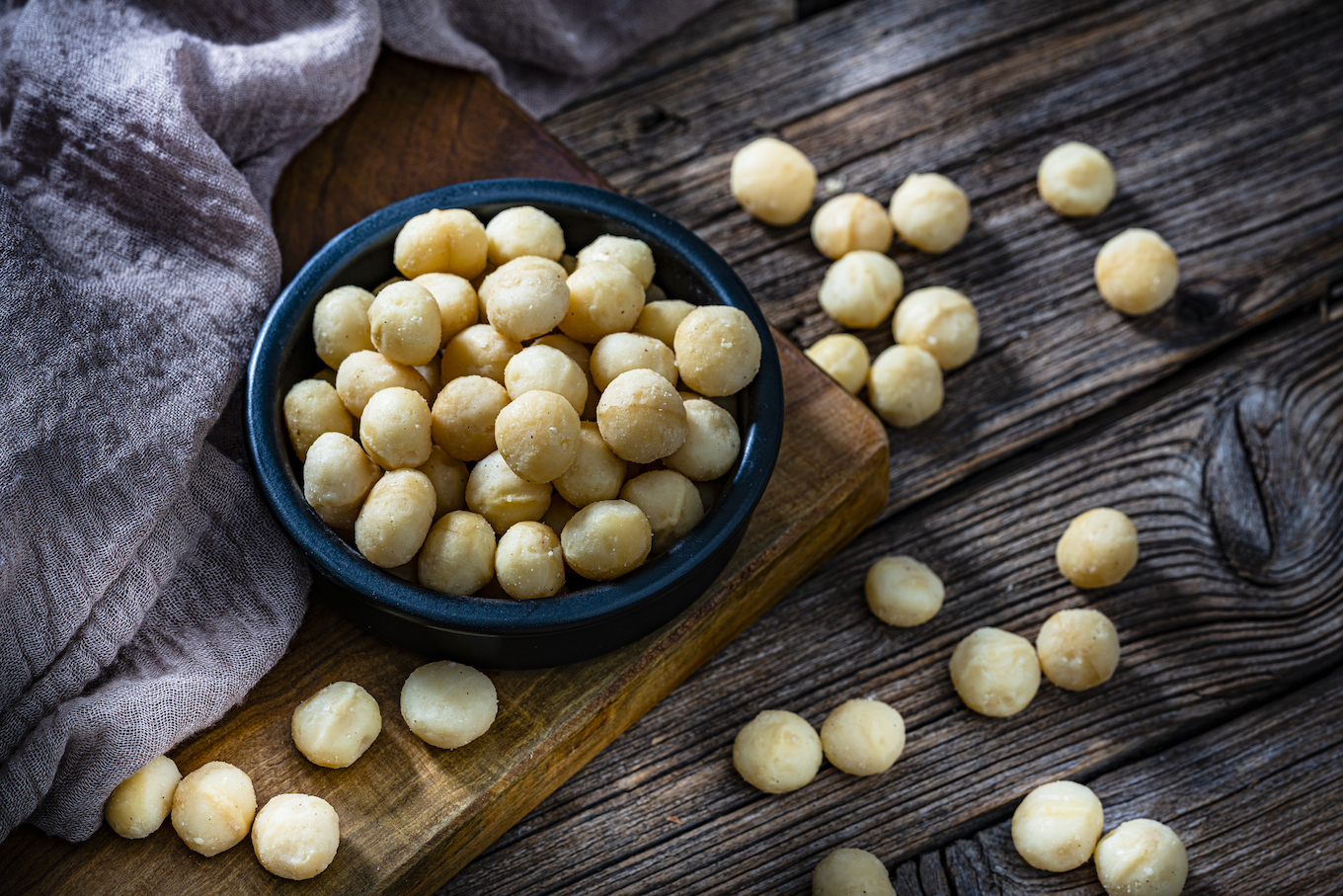 Macadamia nuts bowl on dark rustic table