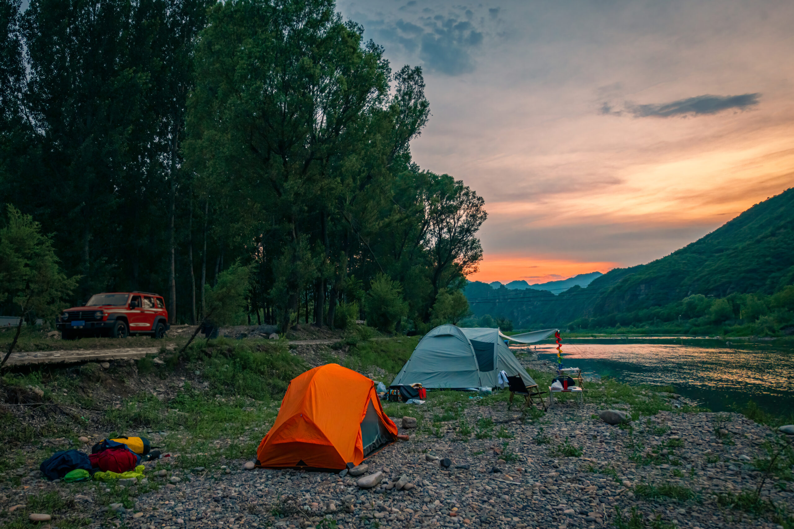 Camp by the river in the setting sun