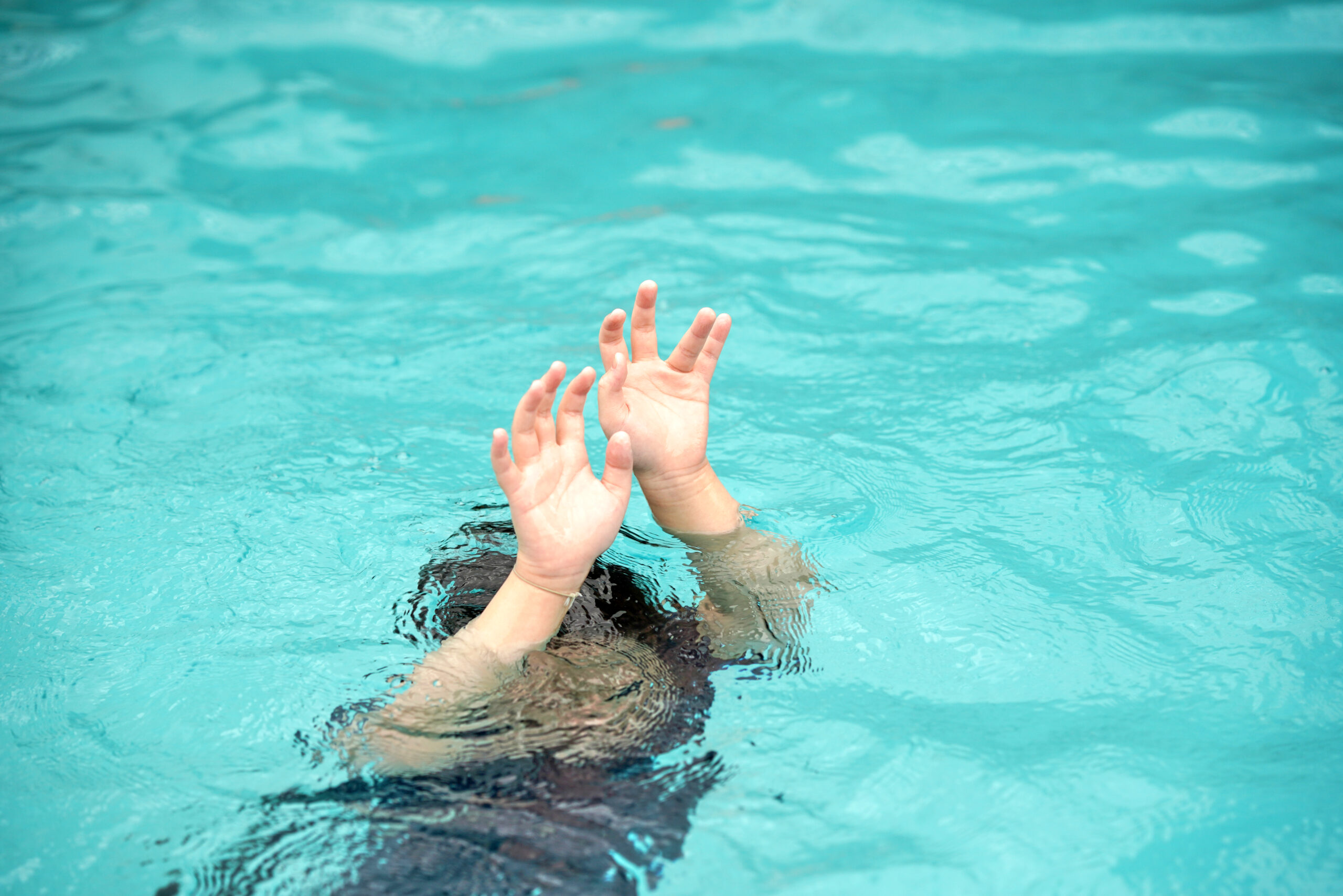 emergency kid drowing in swimming pool show up two hand call for help