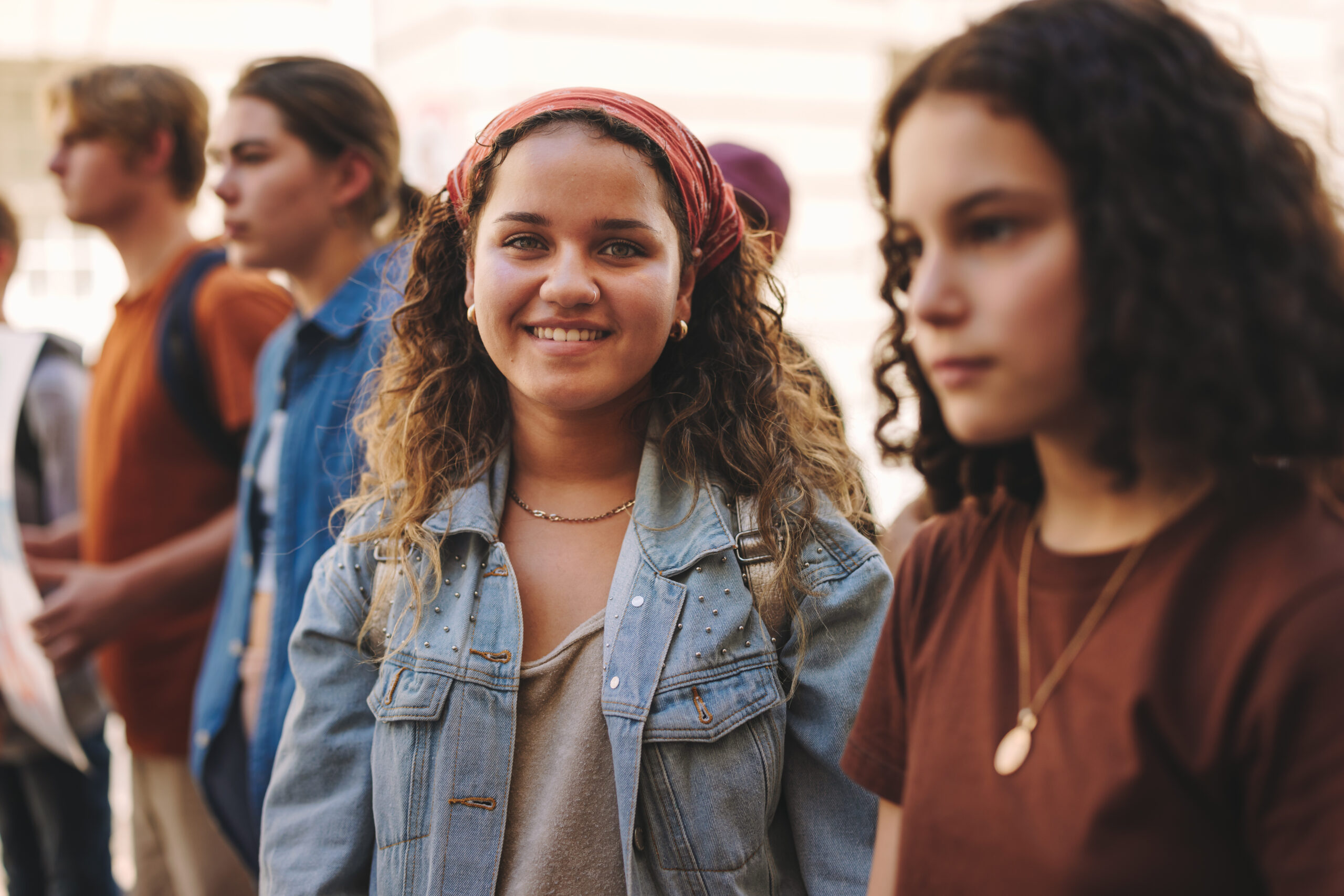 Happy teenage girl protesting with a group of demonstrators in the city