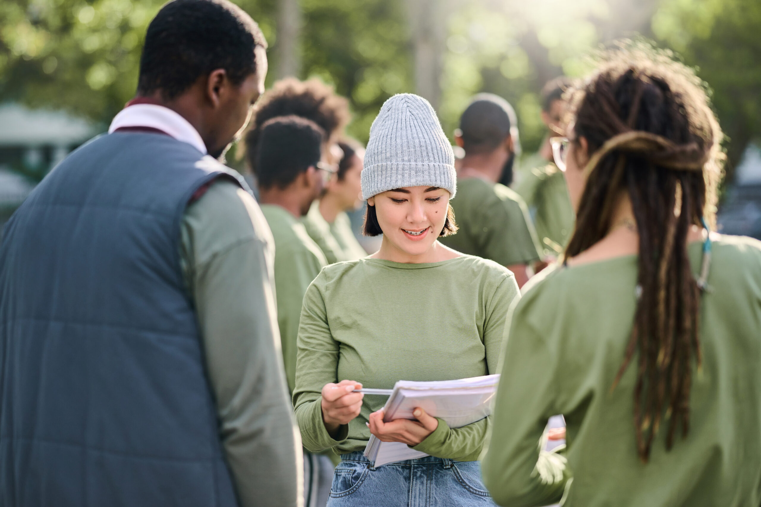 Volunteering, team and people in nature for community service, support and planning of leadership goals. Ngo, charity person with schedule or task management in forest, park or eco friendly project