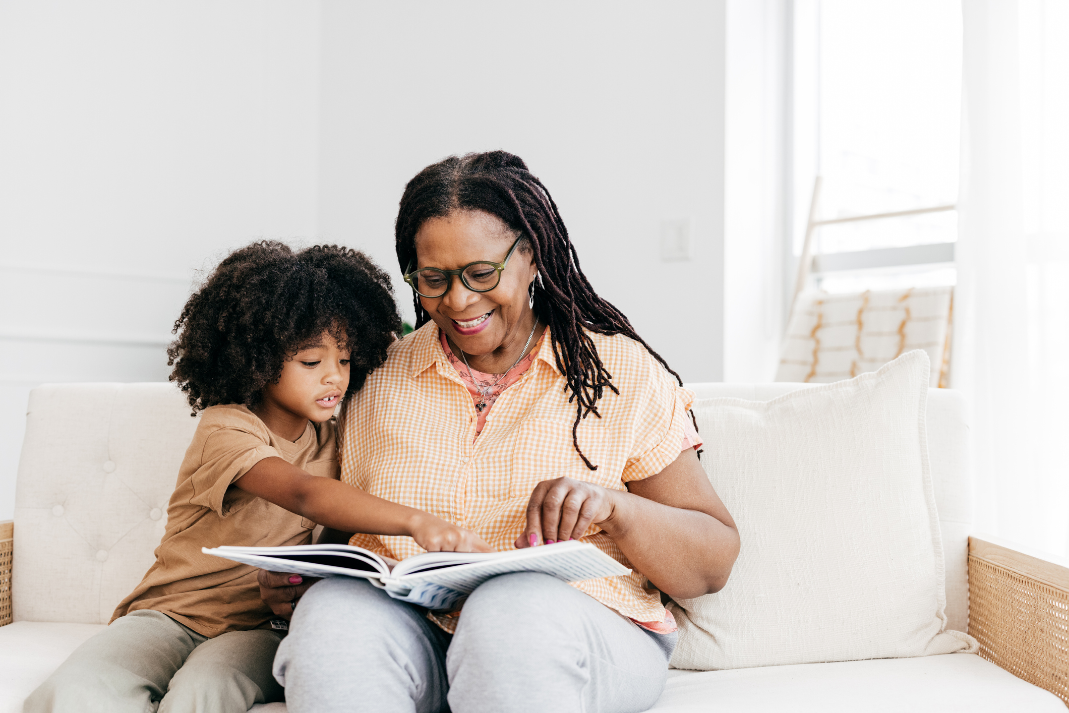 Grandchildren and grandmother reading a story book together