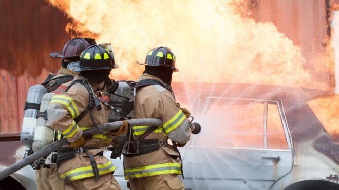 Firefighters putting out car on fire