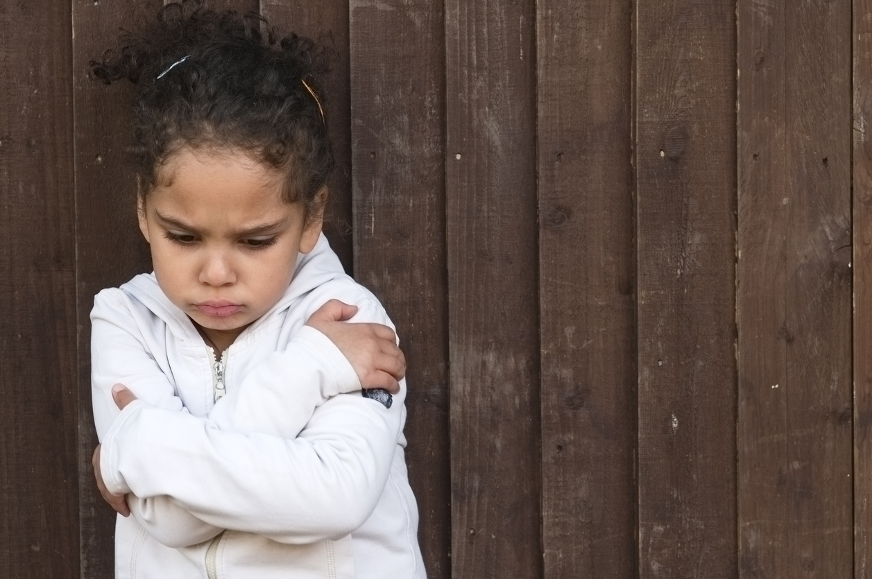 Young little girl with arms crossed and sad