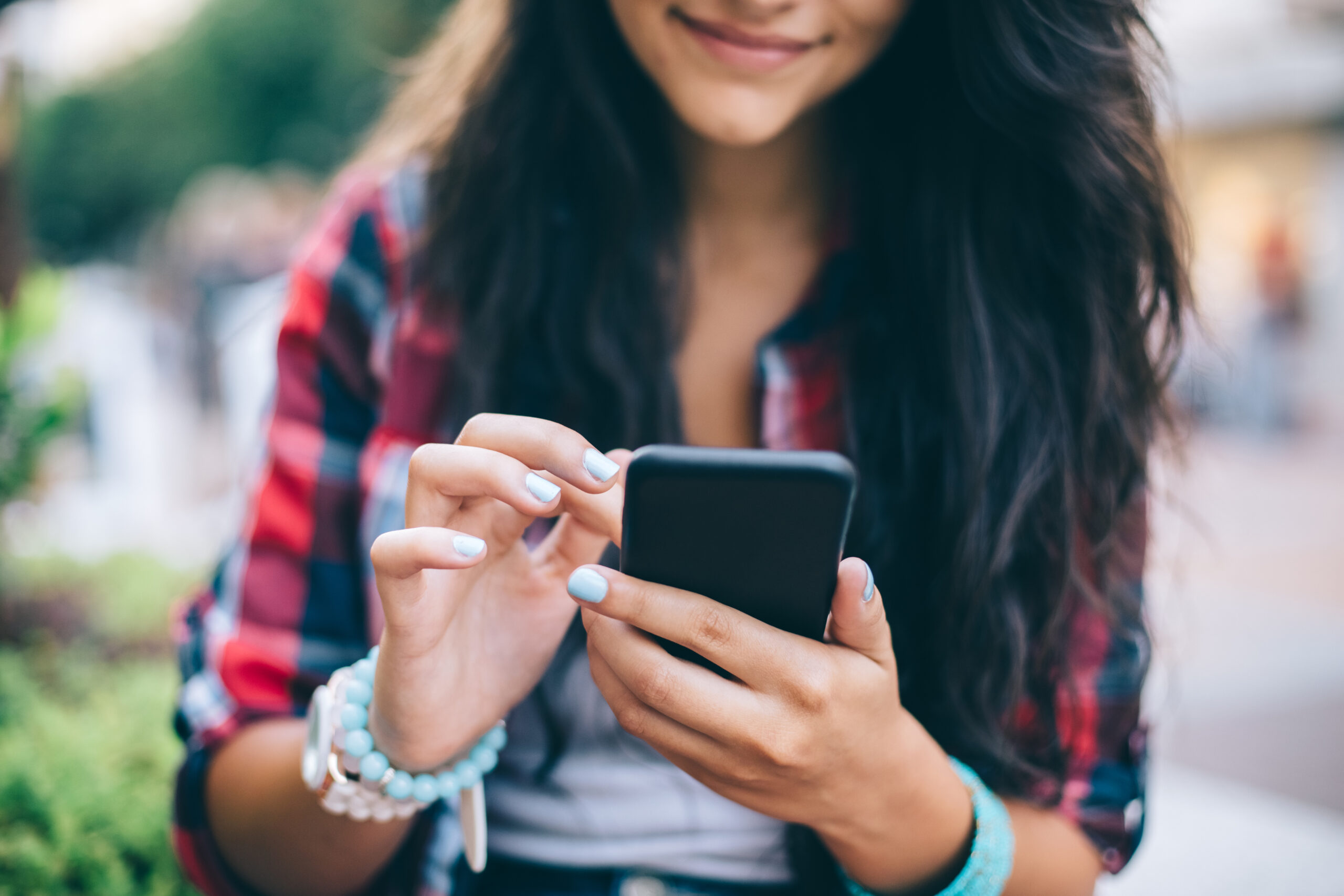 Girl texting on smartphone outside